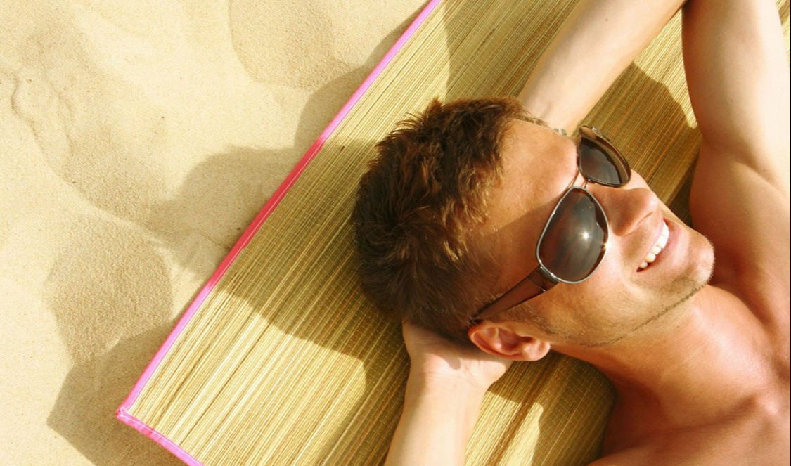 مرد دراز کشیده در آفتاب - برنزه کردن پوست