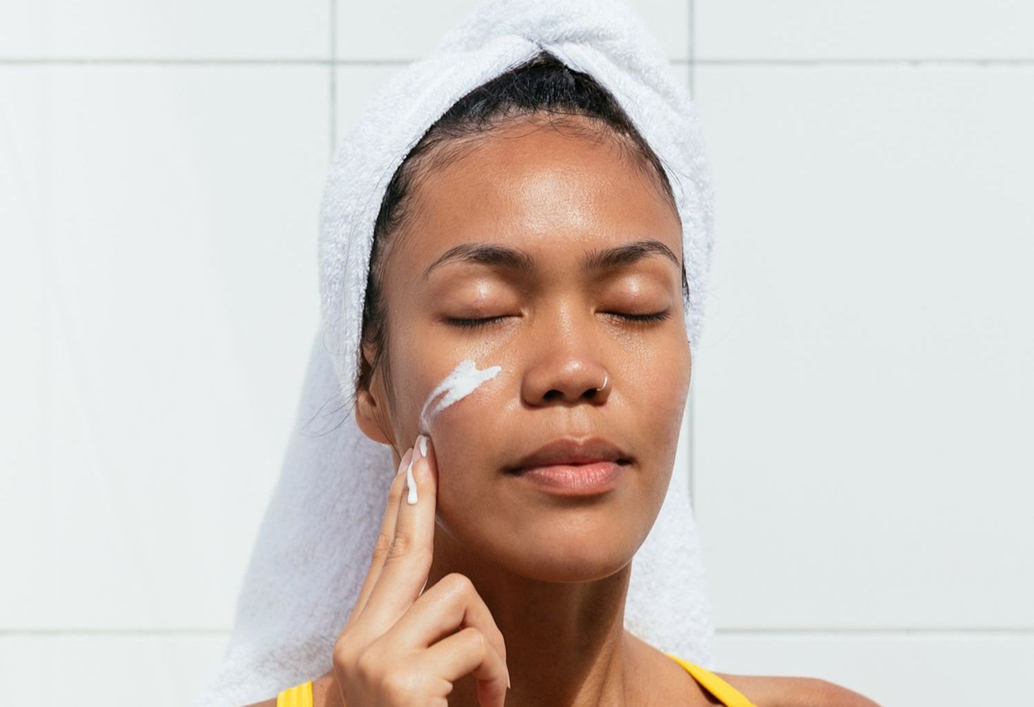 کرم مرطوب کننده روی صورت زن - آبرسانی به پوست خشک