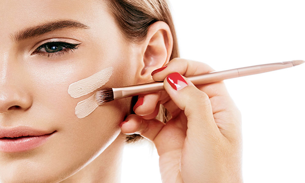 زنی که با براش روی پوستش کرم پودر زده شده است-بهترین کرم پودر 24 ساعته