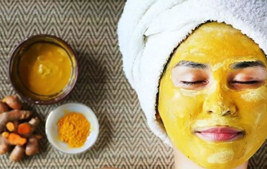 خانمی که ماسک ادویه به صورت خود زده است و حوله سفید به سر دارد - درمان خانگی لک های پوستی