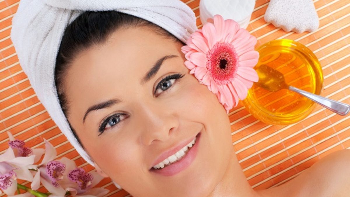 زنی در کنار شیشه عسل- درمان جوش صورت
