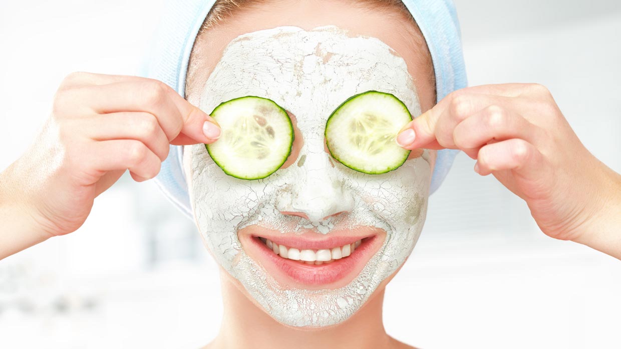 زنی با ماسک خیار و دوععد خیار حلقه ای برروی چشم- ماسک های پاکسازی صورت خانگی